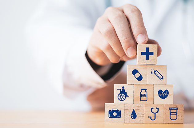 Doctor stacking wood blocks with health icons